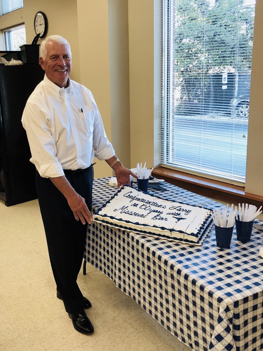 HeplerBroom attorney Larry Hepler with an iced sheet cake with the words "Congratulations Larry on 50 years with Missouri Bar" on top