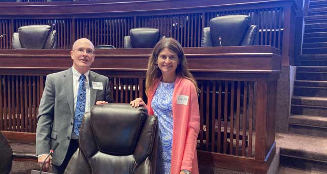 picture of man and woman standing in front of rows of raised seating