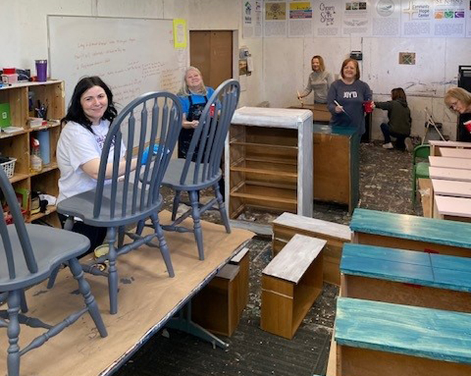 women painting pieces of furniture