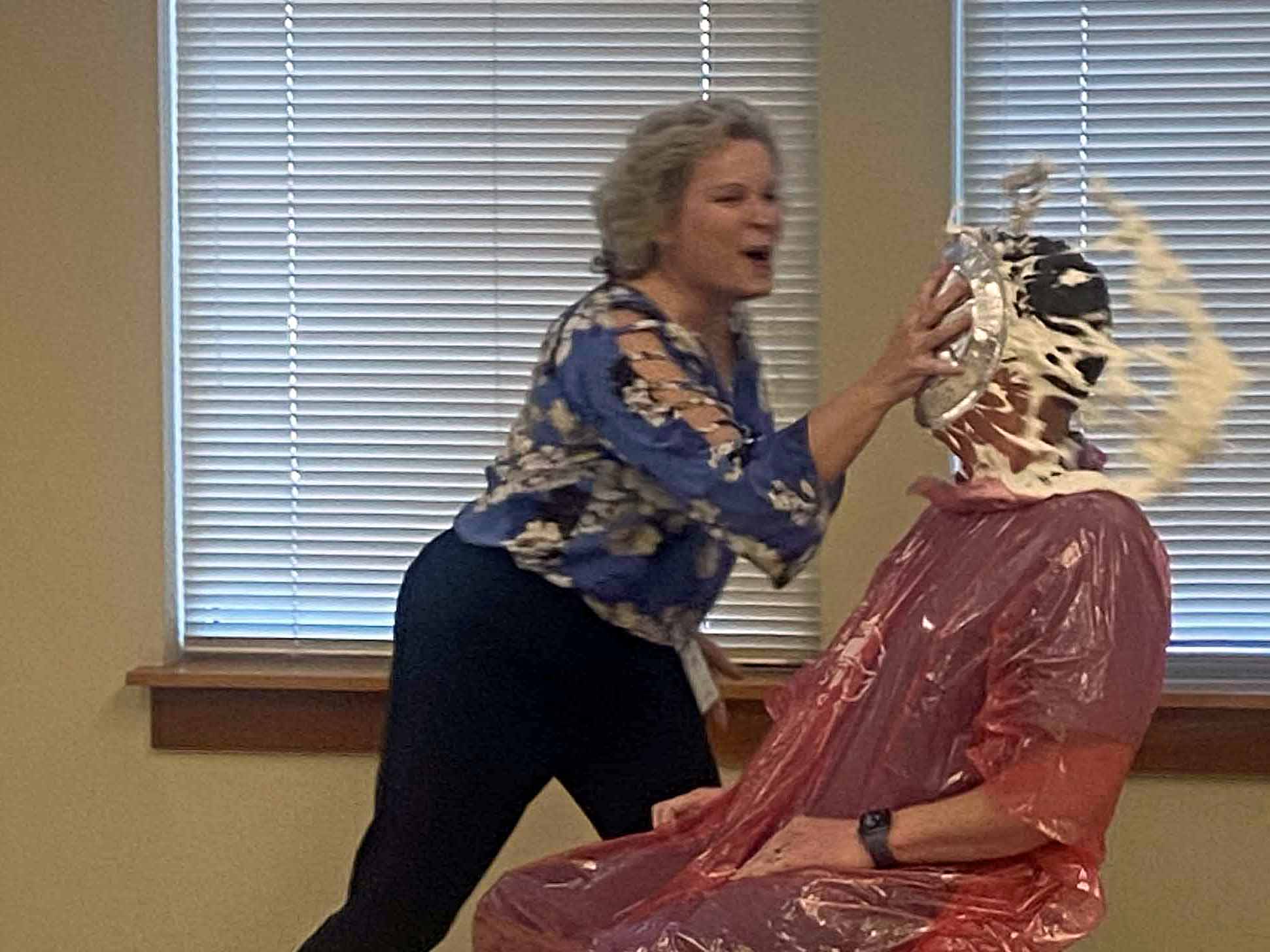 man receiving whipped cream pie in the face