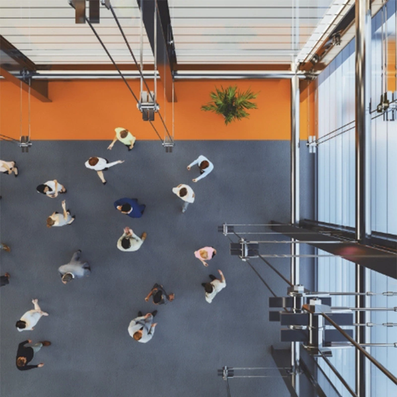 aerial view people walking inside foyer of building with tall glass windows